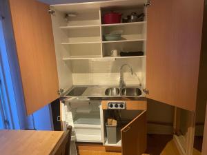 una cocina con fregadero y refrigerador abierto en Cozy Room in Tyresö, en Tyresö