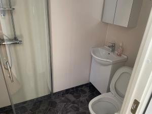 Un baño con ducha, inodoro y lavabo. en Cozy Room in Tyresö, en Tyresö