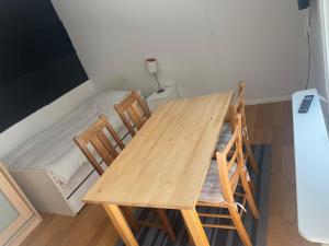 una mesa de madera y sillas en una habitación con cama en Cozy Room in Tyresö, en Tyresö