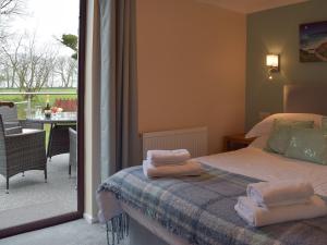 1 dormitorio con 1 cama con toallas. en The Old Coach House, en Hayscastle