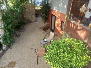 eine Terrasse mit 2 Stühlen, einem Tisch und einem Busch in der Unterkunft Crofty's Celder - Uk35181 in Pool + 2 Fotos