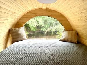a bed in a room with an arched window at Schlaffass Natursee-Chalet mit Sanitärfass,Hot Tub,Sauna,Jacuzzi,angeln in Twist