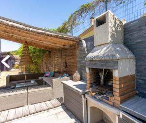 a outdoor pizza oven sitting on a patio at Agréable maison avec jacuzzi in Vinassan