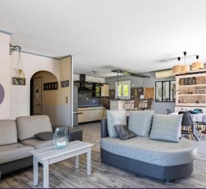 a living room with a couch and a table at Agréable maison avec jacuzzi in Vinassan