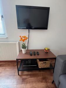 un salon avec une table avec une télévision sur un mur dans l'établissement Haus Waldzeit, inclusief bedlinnen handdoeken en eindservice, à Frankenau 21 autres photos