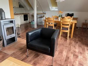 - un fauteuil en cuir noir dans le salon avec une table dans l'établissement Haus Waldzeit, inclusief bedlinnen handdoeken en eindservice, à Frankenau