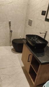 a bathroom with a black sink and a toilet at LA VILLA Resort in Vythiri