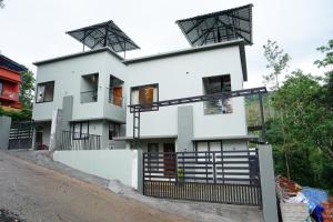 a white house with black balconies on it at LA VILLA Resort in Vythiri