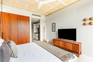 a bedroom with a bed and a flat screen tv at Fabulous Loft With Pool in Cancún