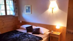 a bedroom with a bed with two pillows on it at Farfalla Penthouse Apartment in Gstaad +11 photos