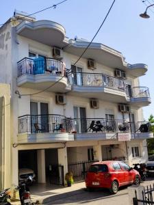 a red car parked in front of a building at stuDio 57 II in Alexandroupoli