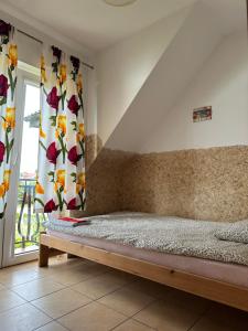 a bedroom with a bed and a window with curtains at Pokoje gościnne Becia in Łeba