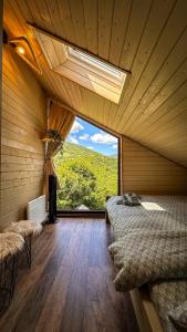 ein Schlafzimmer mit einem Bett und einem großen Fenster in der Unterkunft Amonte Mountain Resort in Muntele Rece + 91 Fotos