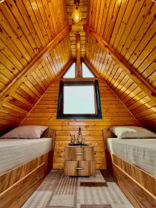 a bedroom with two beds in a wooden cabin at Casa Șoimului - A-Frame in Caransebeş
