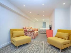ein Wohnzimmer mit zwei Stühlen und einer Couch in der Unterkunft Crofty's Celder - Uk35181 in Pool