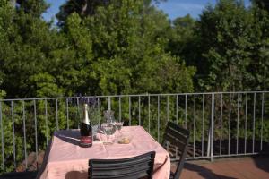 a table with a bottle of wine and wine glasses at La stamberga nel bosco in Asciano Pisano
