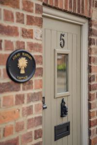 ein Schild an einer Ziegelmauer neben einer Tür in der Unterkunft Straw Plaiters Cottage in Wendover