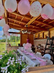 a table with pink and white balloons hanging from a ceiling at Casa Șoimului - A-Frame in Caransebeş