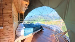 a room with a bed in a tent with a window at Glamp Peaks Mestia in Mestia