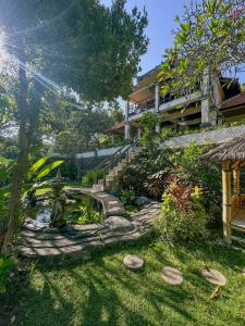 a garden with a pond in front of a building at Dejaviews Resort in Singaraja