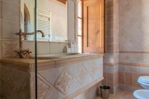a bathroom with a sink and a mirror and a toilet at Charming&Luxury Villa near Assisi, Service Experience Exclusive in Valfabbrica