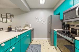 Una cocina con gabinetes azules y un refrigerador de acero inoxidable. en Birdie on the 17th Pool Pickleball Restaurant, en Branson