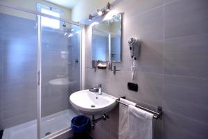 a white bathroom with a sink and a shower at Hotel Alaska in Rimini +50 photos