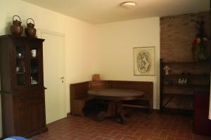 a dining room with a table and a shelf at La stamberga nel bosco in Asciano Pisano