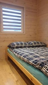 a bed in a room with a window at Błękitna Laguna 600m od morza in Rusinowo