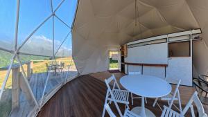 a room with a table and chairs in a tent at Glamp Peaks Mestia in Mestia