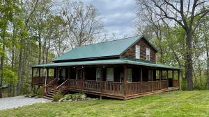 a large wooden house with a green roof at The Lake House At Dale Hollow! in Alpine