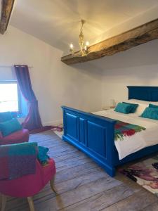 Apple Barn Cottage with 5 Bedrooms في Oradour-sur-Vayres: غرفة نوم بسرير ازرق وكرسيين