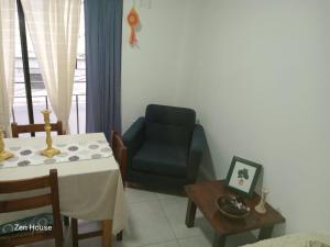 un soggiorno con una sedia blu e un tavolo di Zen house Bs As a Buenos Aires Altre 2 foto