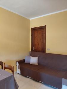 a room with a couch and a wooden door at Casa Coghinas Appartement Mirto in Santa Maria Coghinas