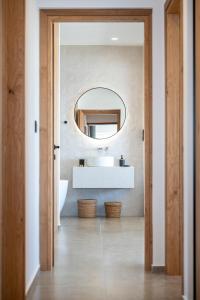 un baño con lavabo y espejo en Mousonas Luxury Living, en Kámpos