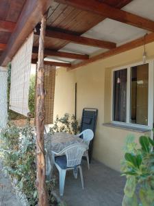 a patio with a table and chairs and a window at Casa Coghinas Appartement Mirto in Santa Maria Coghinas