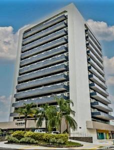 ジョアンペソアにあるHotel Tambau Flat particular908のヤシの木が前に立つ大きな白い建物 +29枚の写真