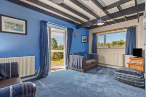 アベルポルスにあるCowslip at Gorslwyd - Sound Retreatの青い壁のリビングルーム(ソファ付)