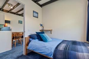 アベルポルスにあるCowslip at Gorslwyd - Sound Retreatのベッドルーム1室(青い枕とテーブル付)