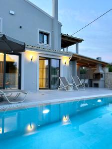 una villa con piscina frente a una casa en Villa Stella, en Gouvia