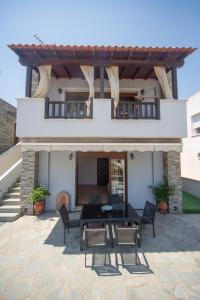 a patio with a table and chairs in front of a house at Villa Castello in Iraklitsa