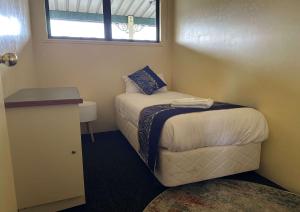 a small bedroom with a bed and a window at Otorohanga Kiwi Holiday Park in Otorohanga +30 photos
