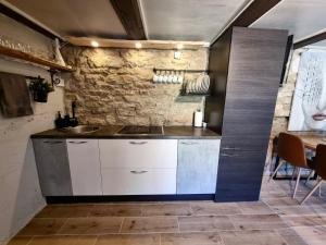 a kitchen with a sink and a stone wall at Suure-Jürna Puhkepesa in Kahutsi