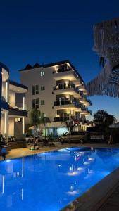 a large swimming pool in front of a building at Summer Gate Hotel in Ksamil