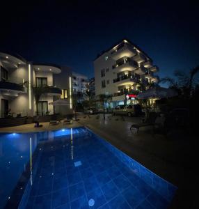 a swimming pool in front of a building at night at Summer Gate Hotel in Ksamil