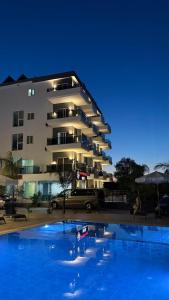 a large building with a swimming pool in front of it at Summer Gate Hotel in Ksamil