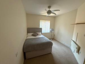 a bedroom with a bed and a ceiling fan at Stylish 1-Bed gated Flat with free Parking and steps from Bournemouth Beach in Bournemouth