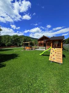a playground with a slide in a grass field at Cabana Mirajul in Rimetea +28 photos