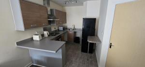 a kitchen with wooden cabinets and a counter top at Stylish 1-Bed gated Flat with free Parking and steps from Bournemouth Beach in Bournemouth