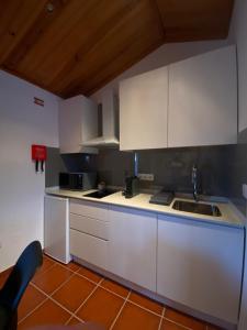 Alqueidão da SerraにあるDa Serra Studio Houseの白いキャビネットとシンクのあるキッチン +14枚の写真